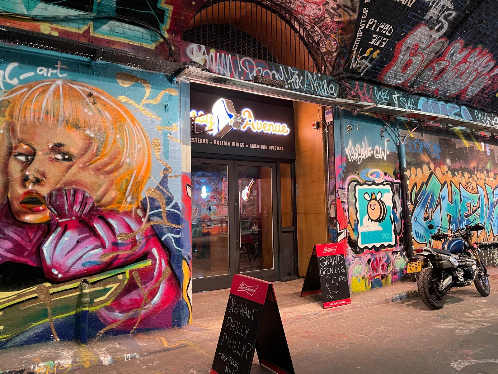 Graffiti-clad railway arch exterior of new American dive bar fit-out