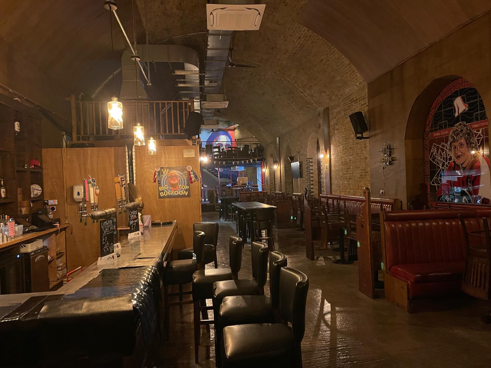 Interior bar fit-out with timber bar, leather booths and feature lighting in vaulted arch