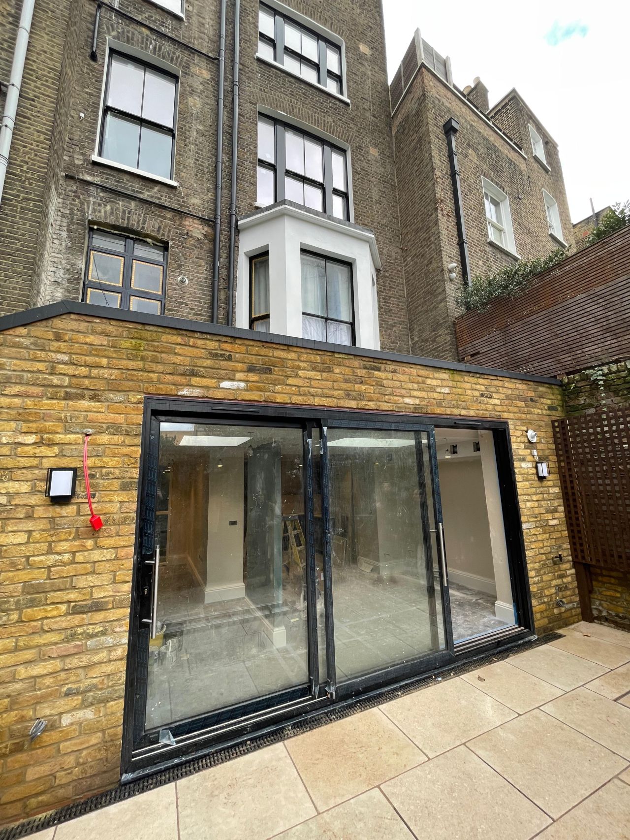 Rear lower-ground extension with sliding glass doors on a London townhouse