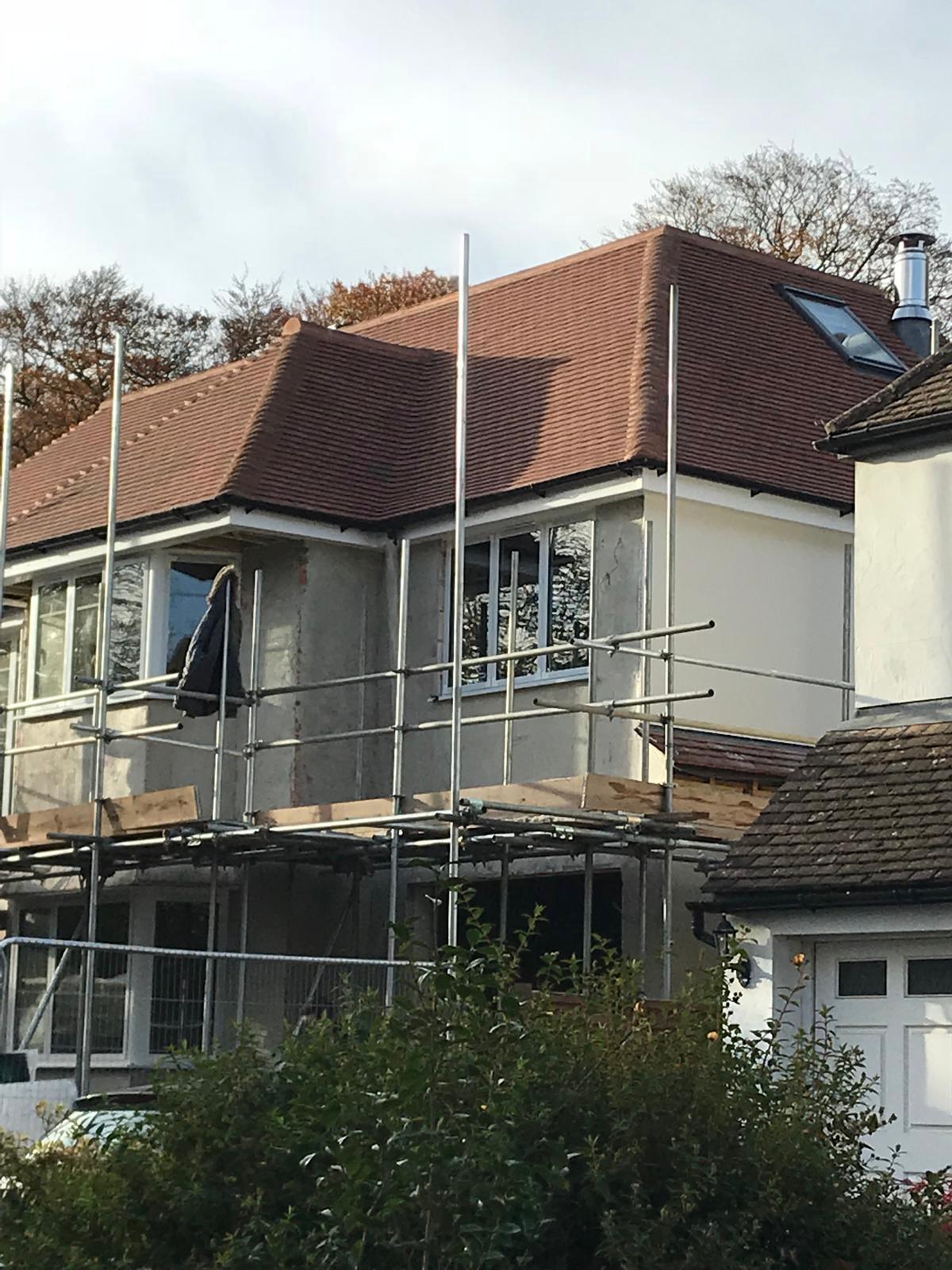 Hip-to-gable loft conversion exterior with new tiled roof and scaffolding