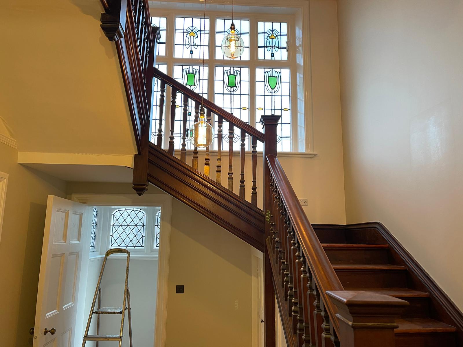 Restored period staircase and stained glass window during loft refurbishment