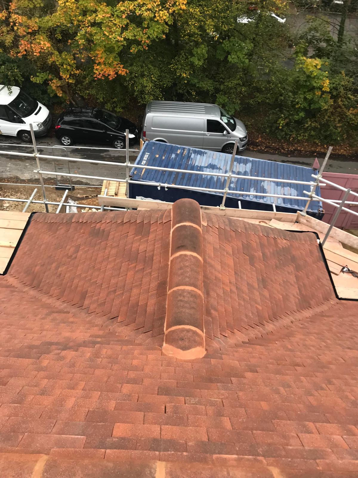 Newly tiled hipped roof viewed from above with ridge tiles in place