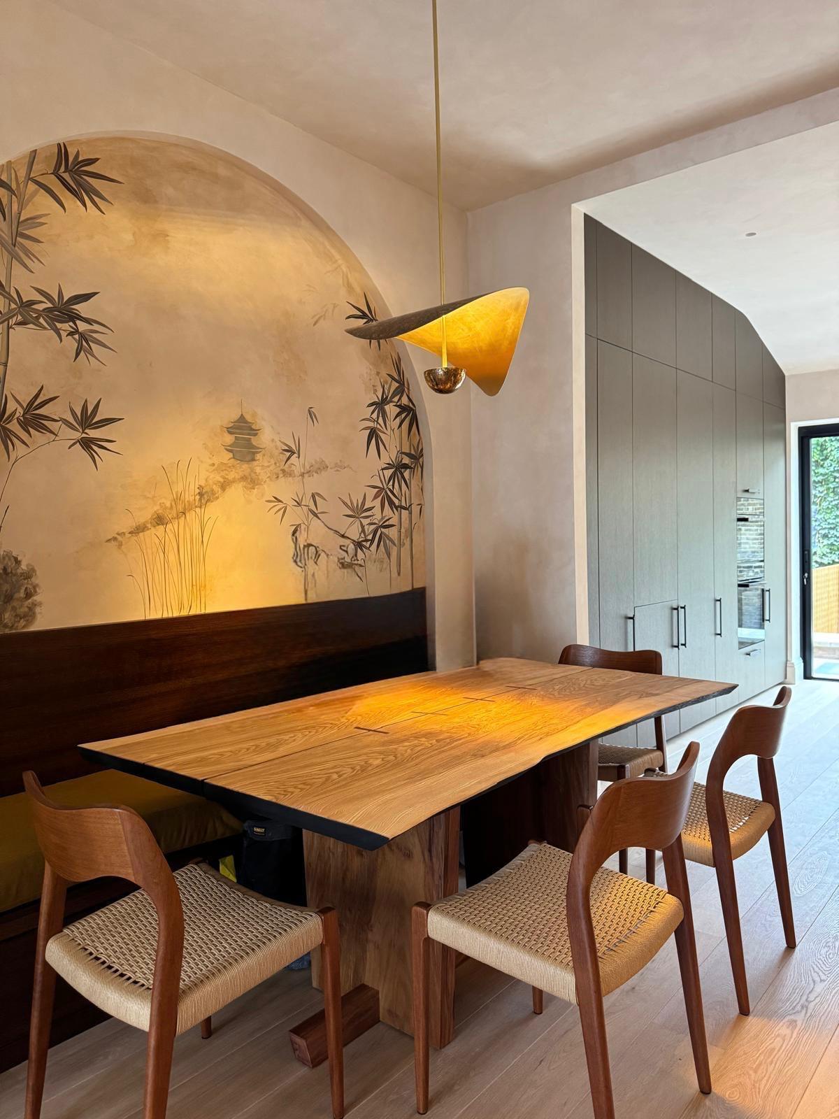 Open-plan dining area with hand-painted bamboo mural, oak table and bespoke kitchen joinery