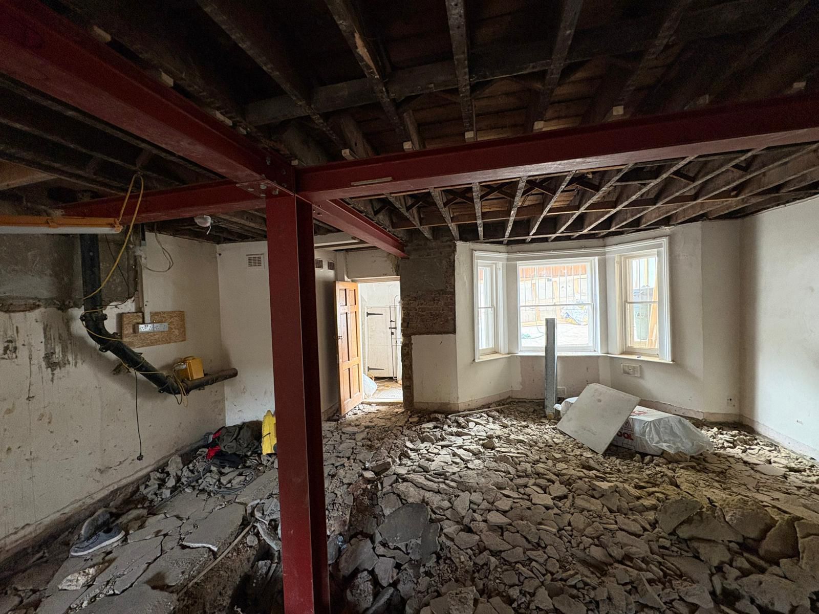 Structural strip-out with new red steel beams installed in a London townhouse