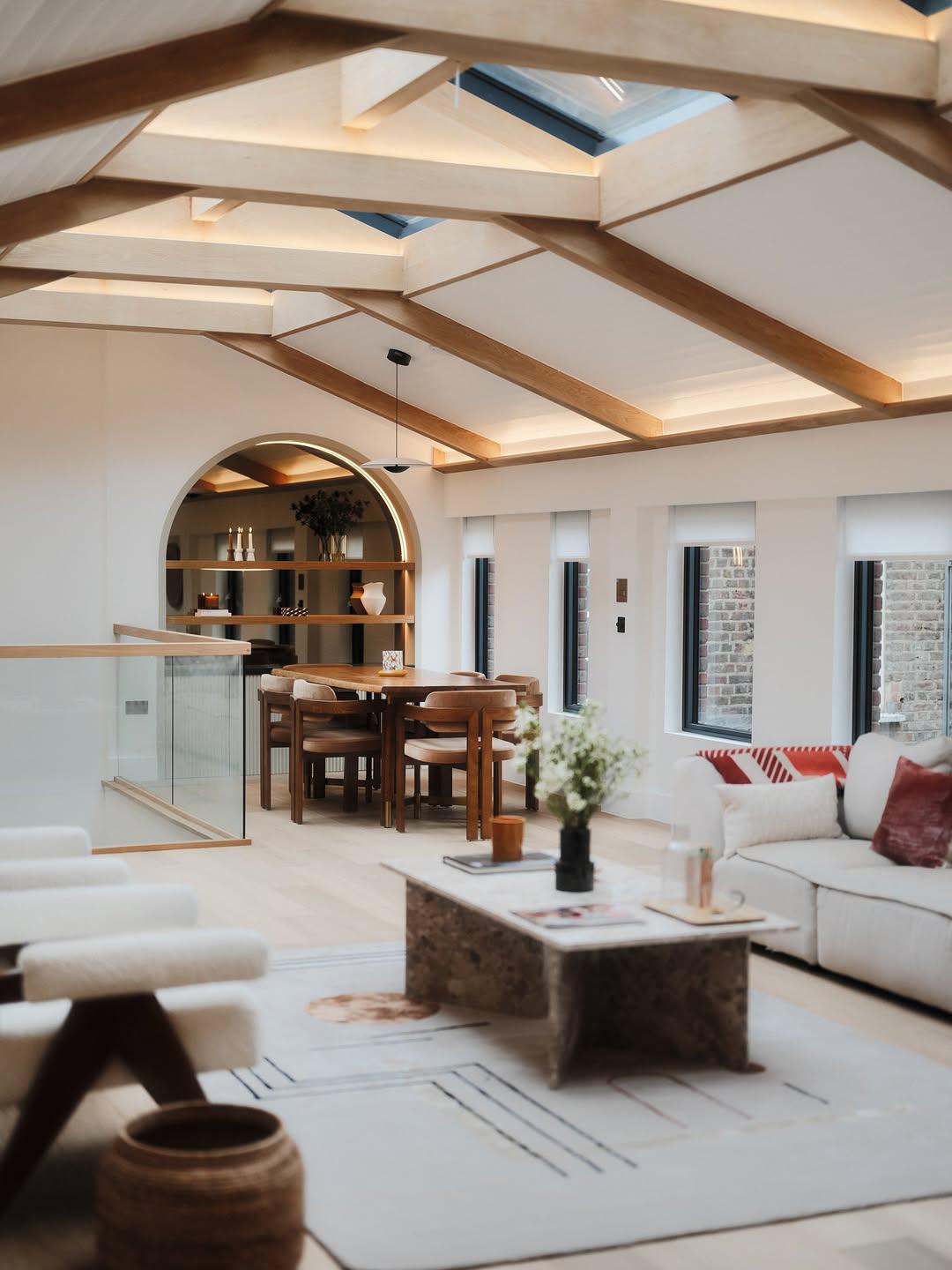 Loft living and dining space with arched joinery and exposed timber beams