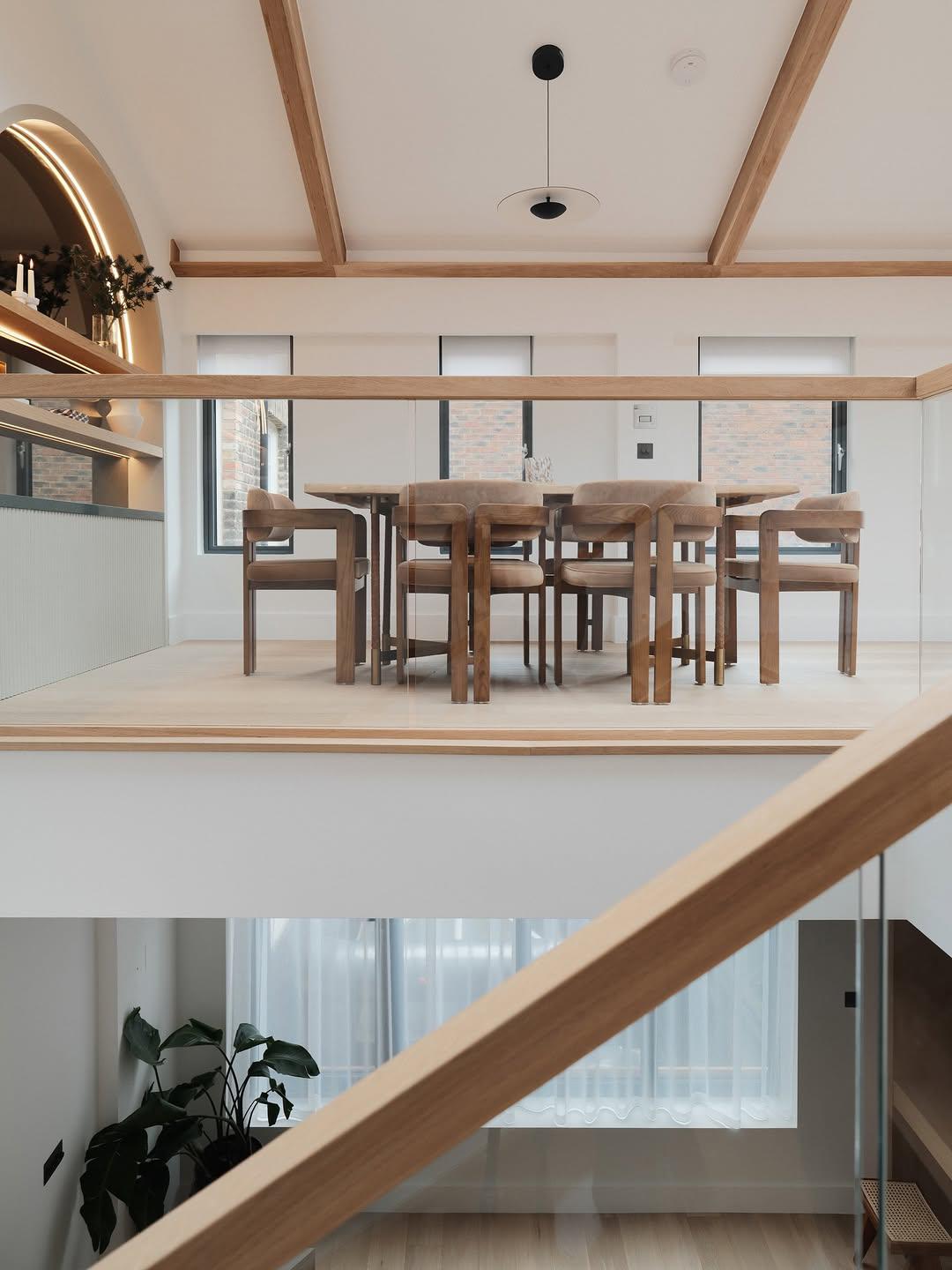 Mezzanine dining area with glass balustrade and timber beams