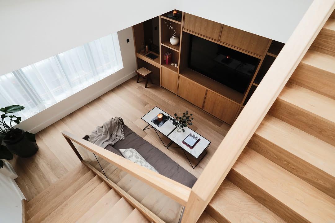 Snug living room viewed from staircase with bespoke oak media wall