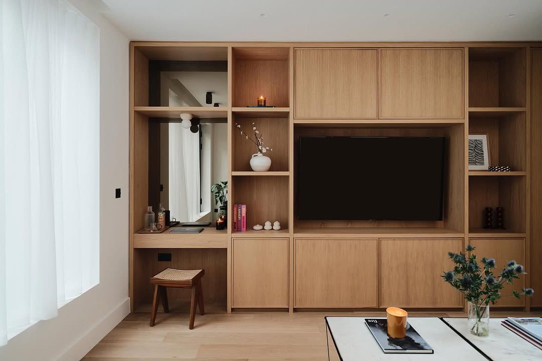 Bespoke oak media wall with integrated desk and shelving in refurbished living room