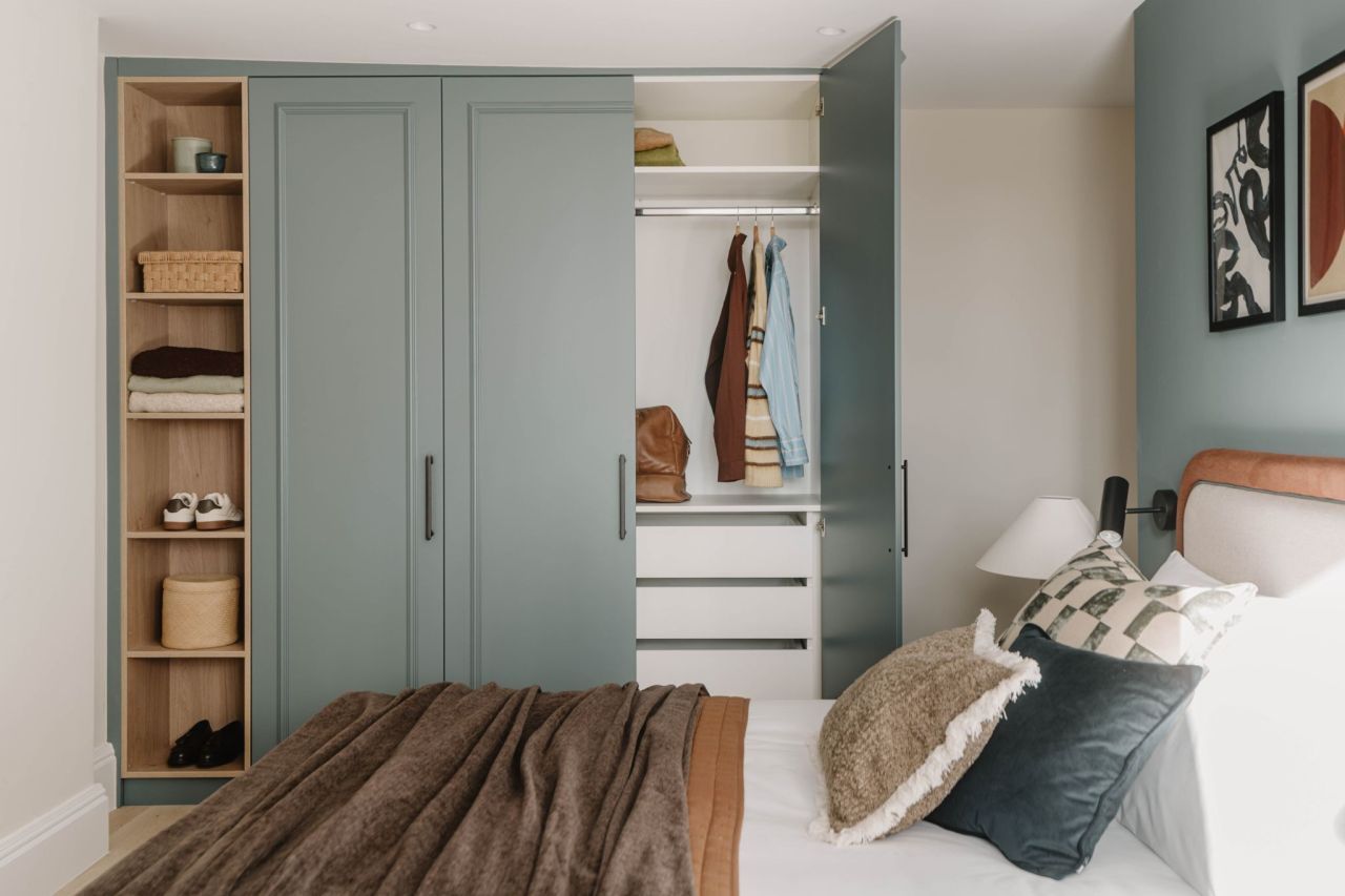 Bespoke fitted wardrobes in sage green with open oak shelving
